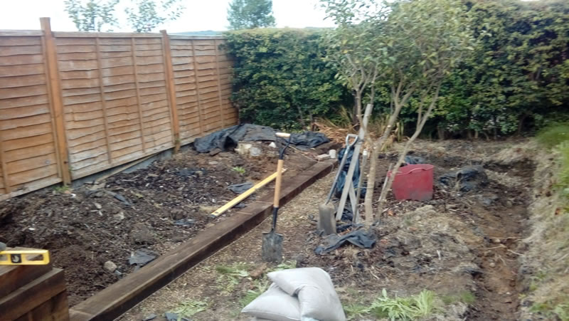 Winch wen garden dirt to left next to a fence one sleeper installed
